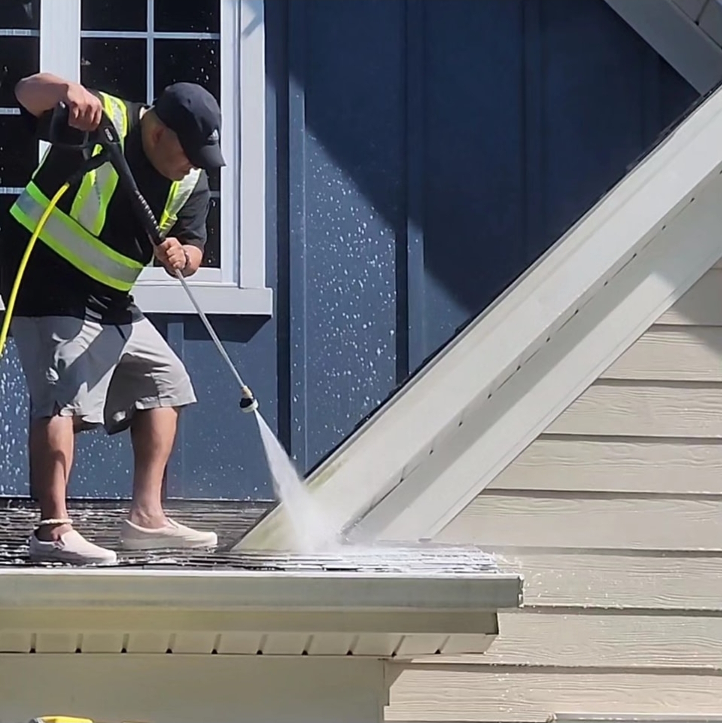 Professional pressure washing service — technician cleaning a roof with a high-pressure spray